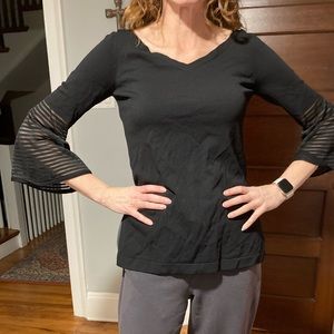 Black top with interesting sleeve- tag is cut- probably a medium